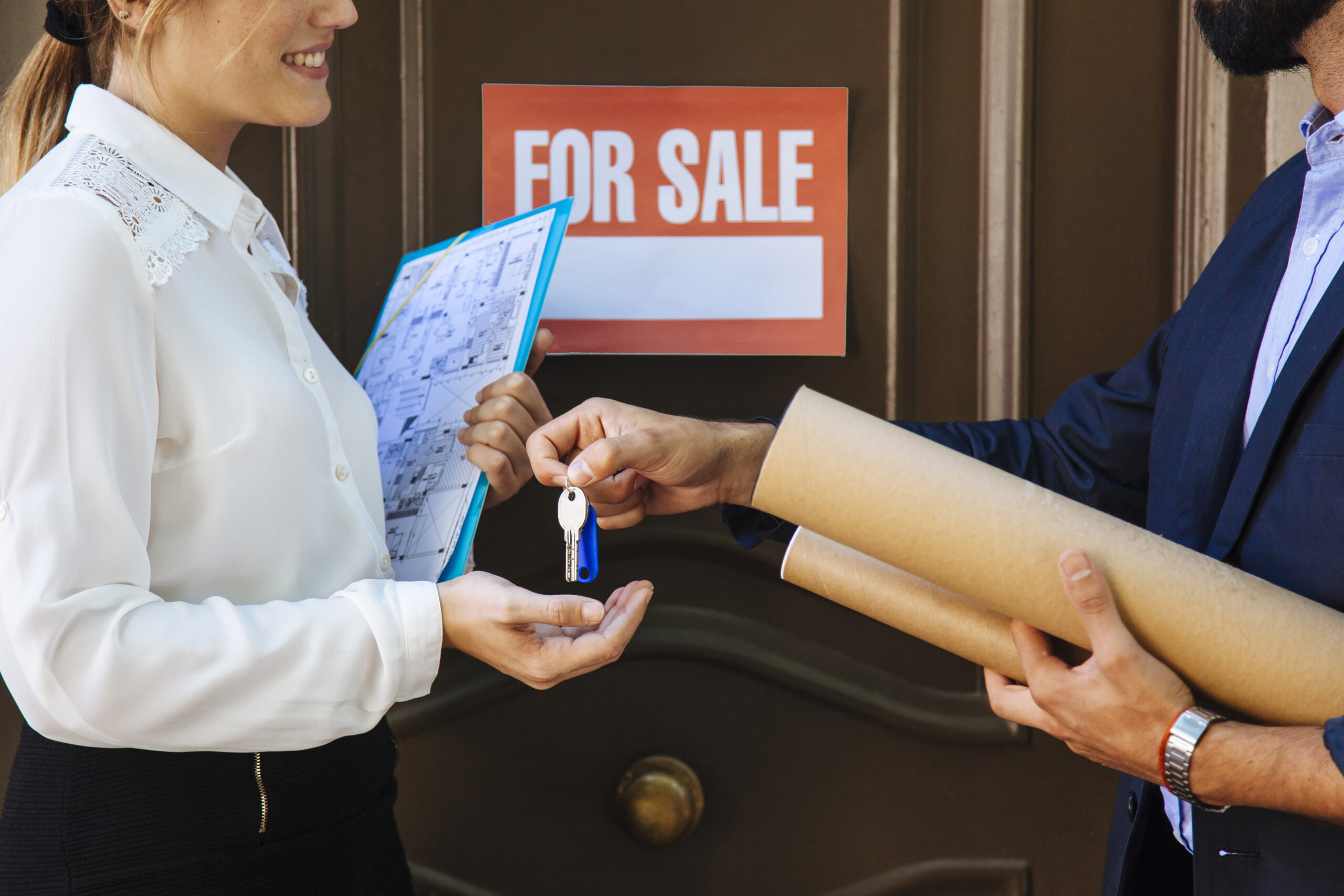 woman-receiving-key-from-real-estate-agent